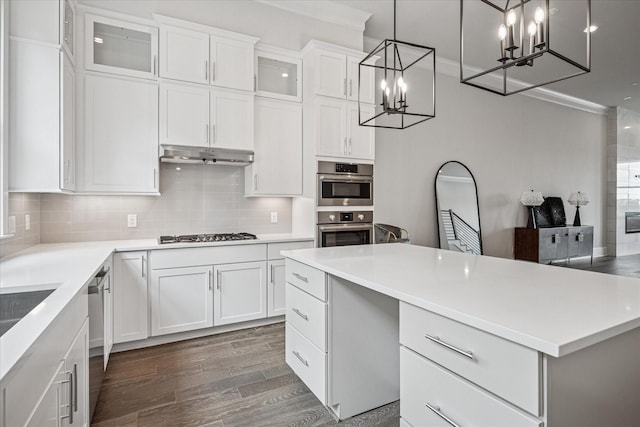 4122 Belt Line Rd, Addison, TX 75001 - kitchen featuring a chandelier, appliances with stainless steel finishes, wood finished floors, decorative backsplash, and ornamental molding