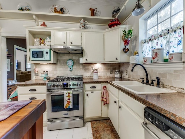 932 Williams St, Rockwall, TX 75087 - kitchen featuring appliances with stainless steel finishes, under cabinet range hood, decorative backsplash, light tile patterned floors, and open shelves