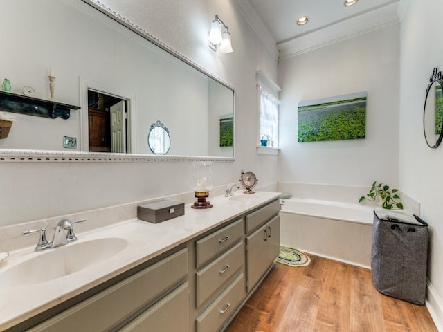 932 Williams St, Rockwall, TX 75087 - bathroom with double vanity, crown molding, a garden tub, wood finished floors, and recessed lighting