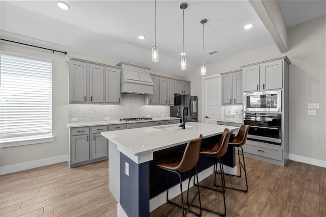 1840 Big Spring Dr, Forney, TX 75126 - kitchen featuring gray cabinetry, stainless steel appliances, custom range hood, light countertops, and backsplash