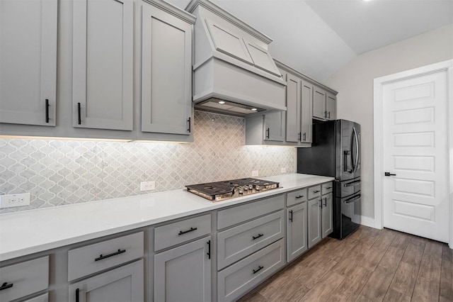 1840 Big Spring Dr, Forney, TX 75126 - kitchen featuring gray cabinets, stainless steel gas stovetop, refrigerator with ice dispenser, premium range hood, and decorative backsplash