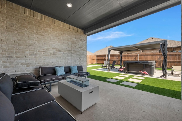 view of patio / terrace with a fenced backyard, an outdoor living space with a fire pit, and a hot tub