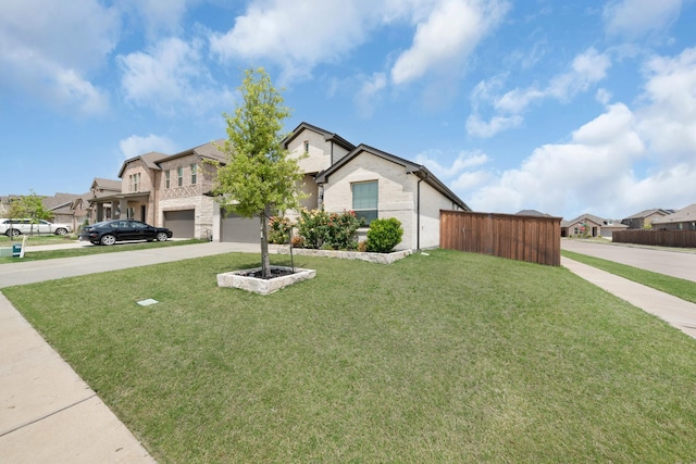 view of front of home featuring a residential view, concrete driveway, fence, brick siding, and a front yard