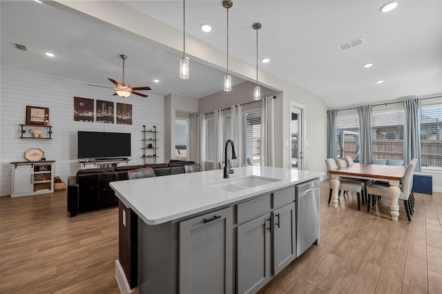 1840 Big Spring Dr, Forney, TX 75126 - kitchen with stainless steel dishwasher, gray cabinetry, light wood finished floors, healthy amount of natural light, and recessed lighting