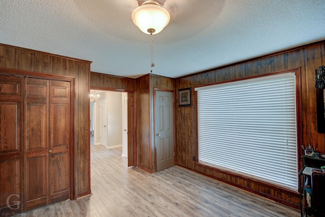 221 Summit Dr, Bossier City, LA 71111 - interior space featuring a closet, wooden walls, light wood-style flooring, and a textured ceiling
