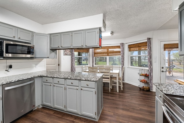18341 Shore Dr, Kemp, TX 75143 - kitchen with a peninsula, a textured ceiling, appliances with stainless steel finishes, and gray cabinetry