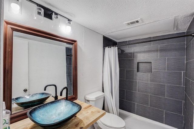 8110 Skillman St Unit 1067, Dallas, TX 75231 - full bathroom featuring a textured ceiling and a tile shower