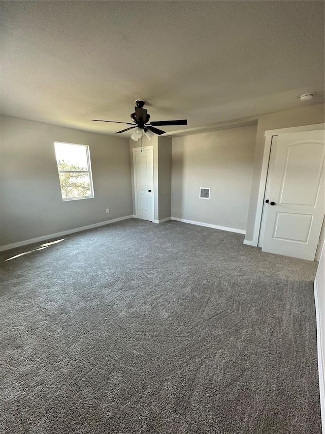spare room featuring ceiling fan, baseboards, carpet floors, and a textured ceiling