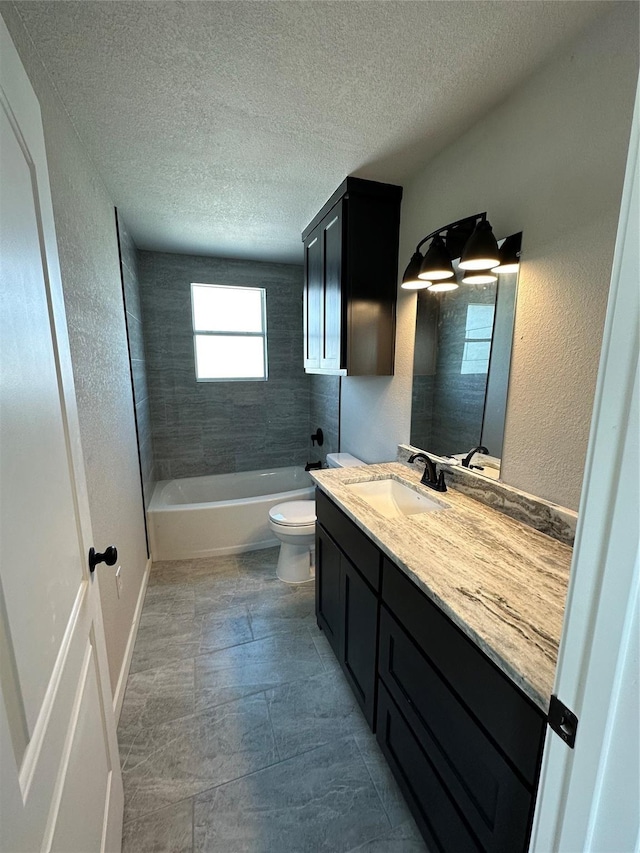 bathroom featuring toilet, a textured ceiling, shower / washtub combination, vanity, and a textured wall