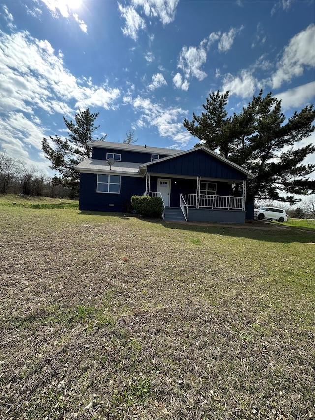 view of front facade featuring a front yard, a porch, and board and batten siding