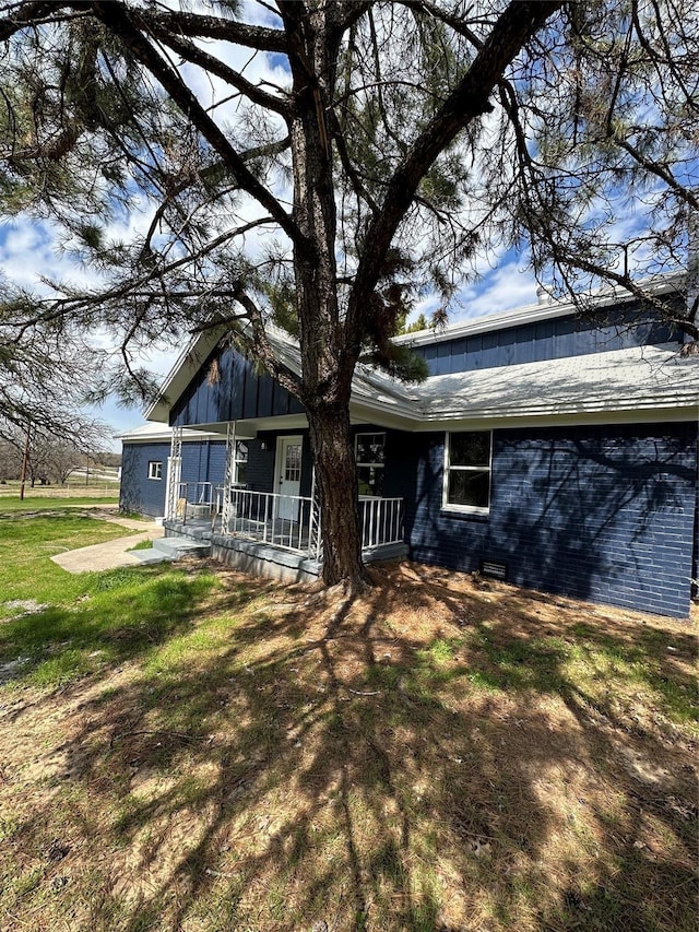 rear view of property with a lawn and covered porch