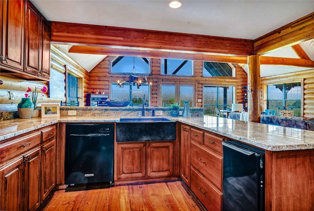 kitchen with a sink, dishwasher, light wood-style floors, vaulted ceiling with beams, and rustic walls
