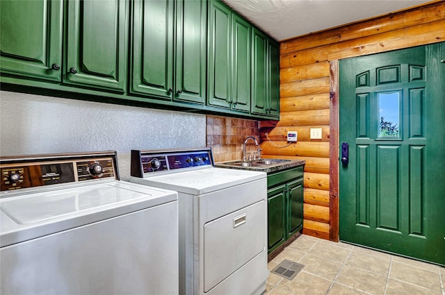 washroom featuring cabinet space, a sink, separate washer and dryer, visible vents, and log walls