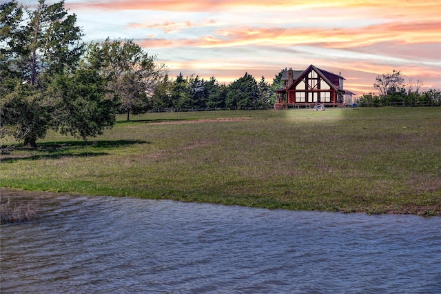 view of yard with a deck with water view