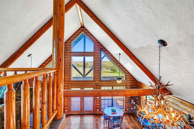 living room with beamed ceiling, rustic walls, hardwood / wood-style flooring, and high vaulted ceiling