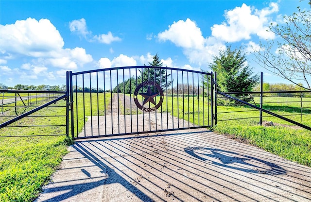 view of gate with a lawn and fence