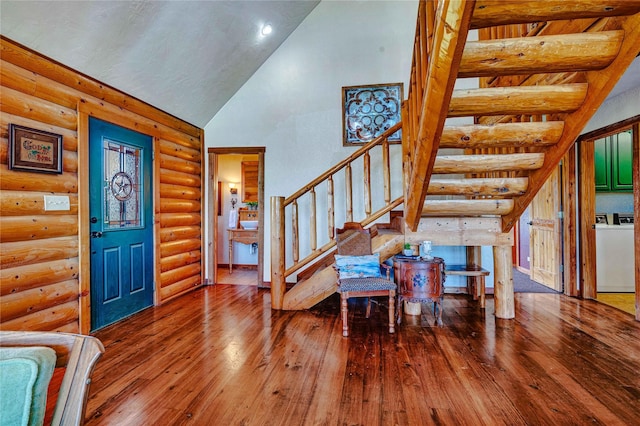 entrance foyer featuring stairway, separate washer and dryer, high vaulted ceiling, wood-type flooring, and log walls