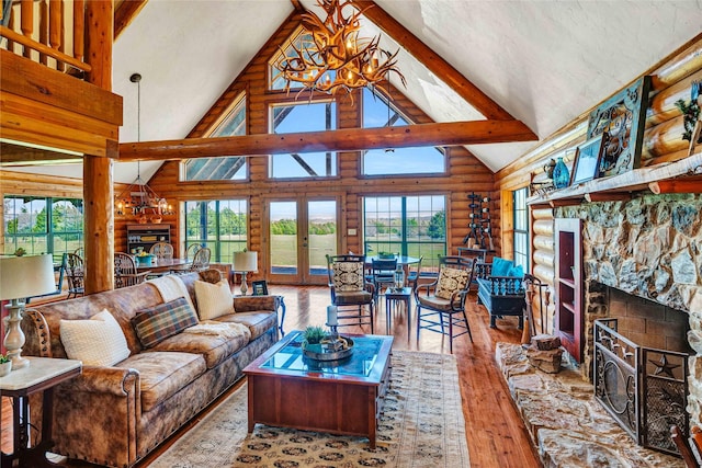 living area featuring wood-type flooring, high vaulted ceiling, a notable chandelier, and log walls