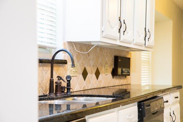 4424 Denver Dr, Plano, TX 75093 - kitchen with tasteful backsplash, dark countertops, dishwasher, white cabinets, and a sink