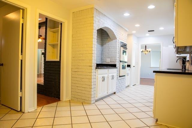 4424 Denver Dr, Plano, TX 75093 - kitchen featuring a sink, dark countertops, double oven, brick wall, and light tile patterned floors