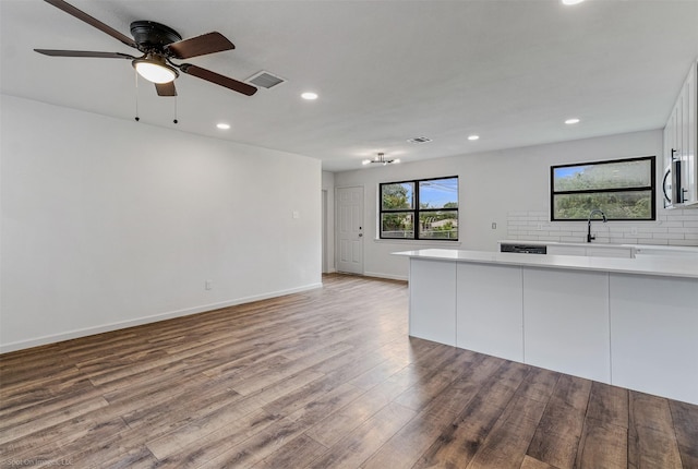 4630 Harvey Dr, Mesquite, TX 75150 - kitchen with a sink, wood finished floors, recessed lighting, stainless steel microwave, and white cabinets