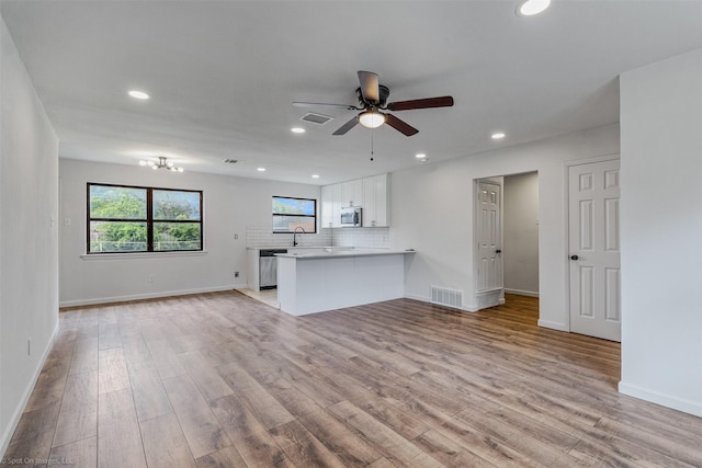 4630 Harvey Dr, Mesquite, TX 75150 - unfurnished living room with light wood-style flooring, ceiling fan, recessed lighting, baseboards, and a sink