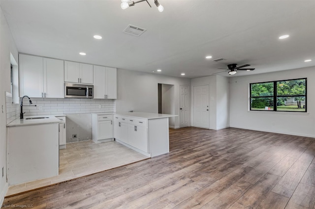 4630 Harvey Dr, Mesquite, TX 75150 - kitchen with stainless steel microwave, open floor plan, a sink, a ceiling fan, and tasteful backsplash