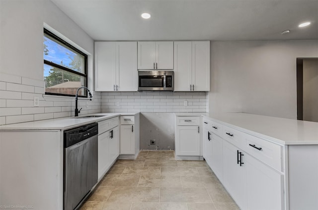 4630 Harvey Dr, Mesquite, TX 75150 - kitchen featuring appliances with stainless steel finishes, a sink, a peninsula, white cabinets, and recessed lighting