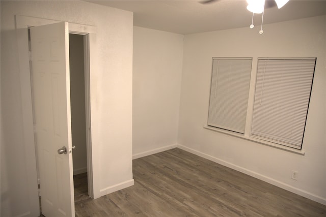 unfurnished bedroom featuring baseboards, a ceiling fan, and dark wood-style flooring