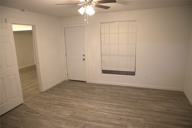 unfurnished room featuring baseboards, ceiling fan, and wood finished floors
