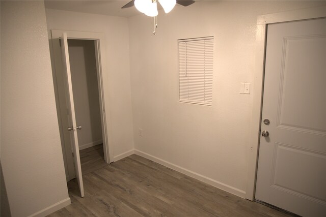 unfurnished bedroom featuring baseboards, ceiling fan, and wood finished floors