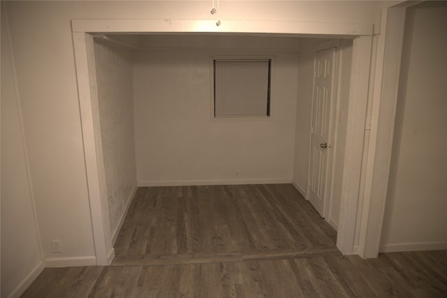 hall featuring baseboards and wood finished floors