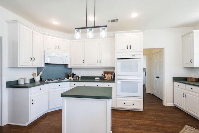 640 County Road 203, Collinsville, TX 76233 - kitchen with dark countertops, visible vents, white cabinets, and white appliances