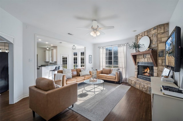 640 County Road 203, Collinsville, TX 76233 - living area featuring visible vents, a stone fireplace, a ceiling fan, and wood finished floors