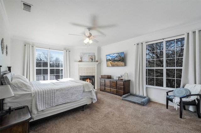 640 County Road 203, Collinsville, TX 76233 - carpeted bedroom with visible vents, crown molding, baseboards, ceiling fan, and a tiled fireplace