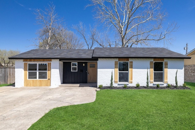 view of front of property featuring a carport, driveway, brick siding, and a front lawn