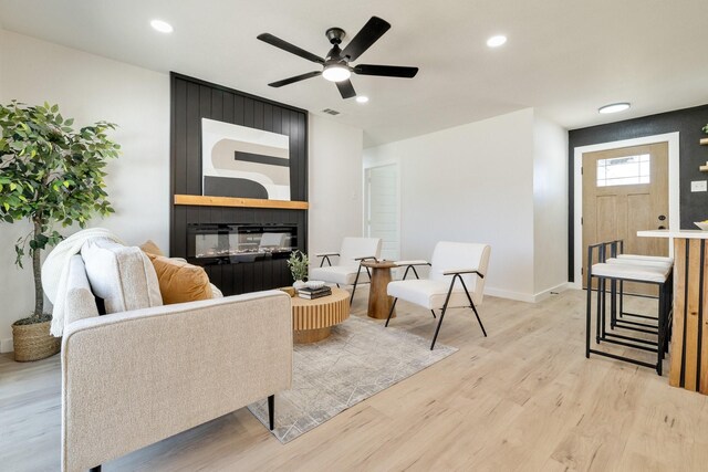 living area featuring visible vents, light wood-style flooring, a ceiling fan, recessed lighting, and baseboards