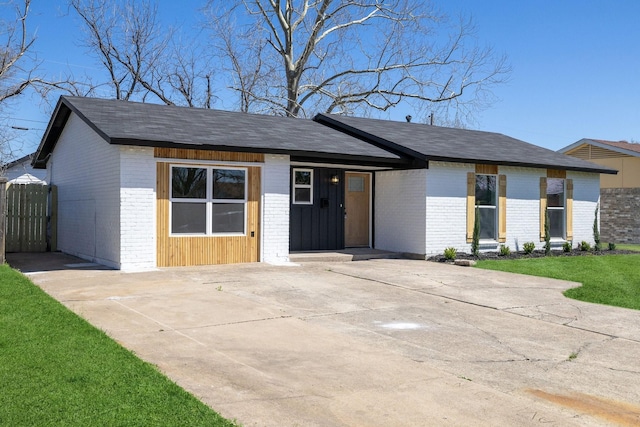 mid-century home with a front lawn and brick siding