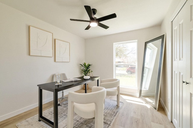 office area featuring baseboards, light wood-style floors, and a ceiling fan
