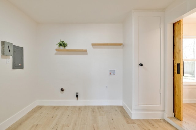washroom featuring electric panel, baseboards, hookup for a washing machine, and light wood finished floors