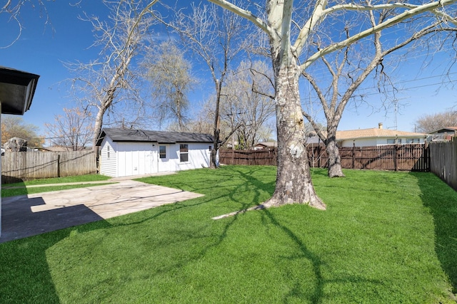view of yard featuring an outbuilding, a fenced backyard, and a patio