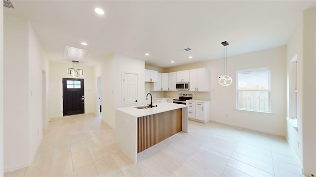 2227 Stoneman St, Dallas, TX 75215 - kitchen featuring stainless steel appliances, a sink, backsplash, a center island with sink, and light tile patterned floors