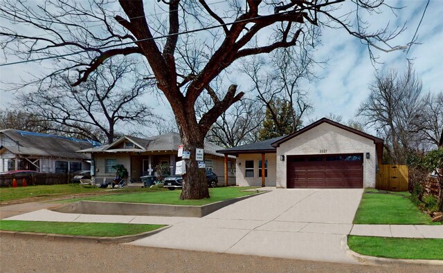 2227 Stoneman St, Dallas, TX 75215 - view of front of house featuring a garage, driveway, and brick siding
