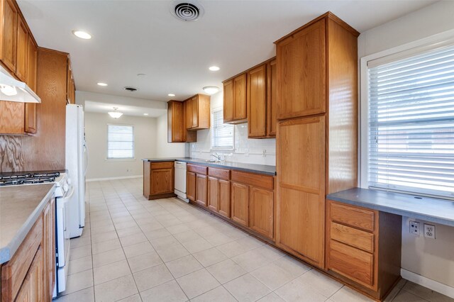 2645 Woodmere Dr, Dallas, TX 75233 - kitchen featuring visible vents, brown cabinets, a sink, tasteful backsplash, and white appliances
