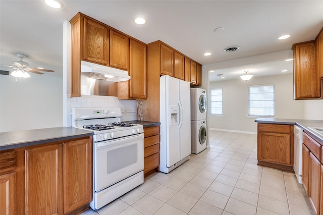 2645 Woodmere Dr, Dallas, TX 75233 - kitchen featuring visible vents, under cabinet range hood, brown cabinets, white appliances, and stacked washer / drying machine