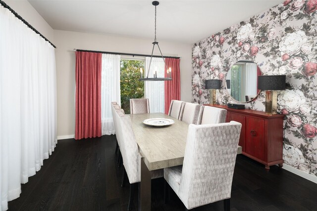 dining area featuring baseboards, wallpapered walls, wood finished floors, and an accent wall