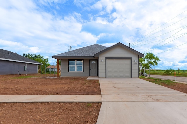 5557 N 10th, Abilene, TX 79601 - view of front facade with concrete driveway, a garage, and a shingled roof