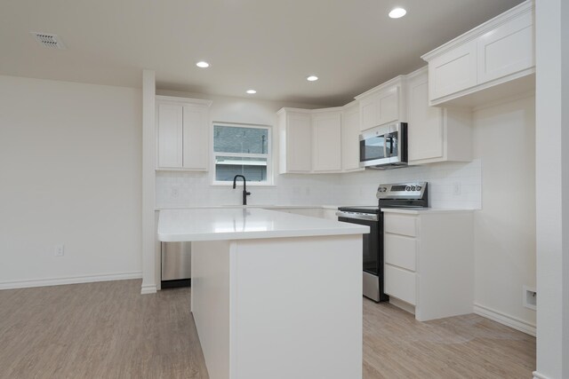 5557 N 10th, Abilene, TX 79601 - kitchen featuring stainless steel appliances, decorative backsplash, light wood-style flooring, a center island, and recessed lighting