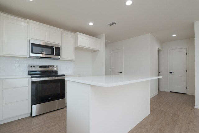 5557 N 10th, Abilene, TX 79601 - kitchen with appliances with stainless steel finishes, light wood-style floors, a center island, decorative backsplash, and recessed lighting