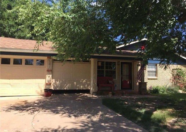 view of front of house featuring concrete driveway, brick siding, and a garage